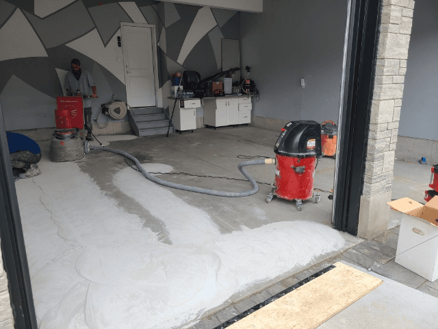 Worn concrete garage floor being ground and resurfaced in a London, Ontario home