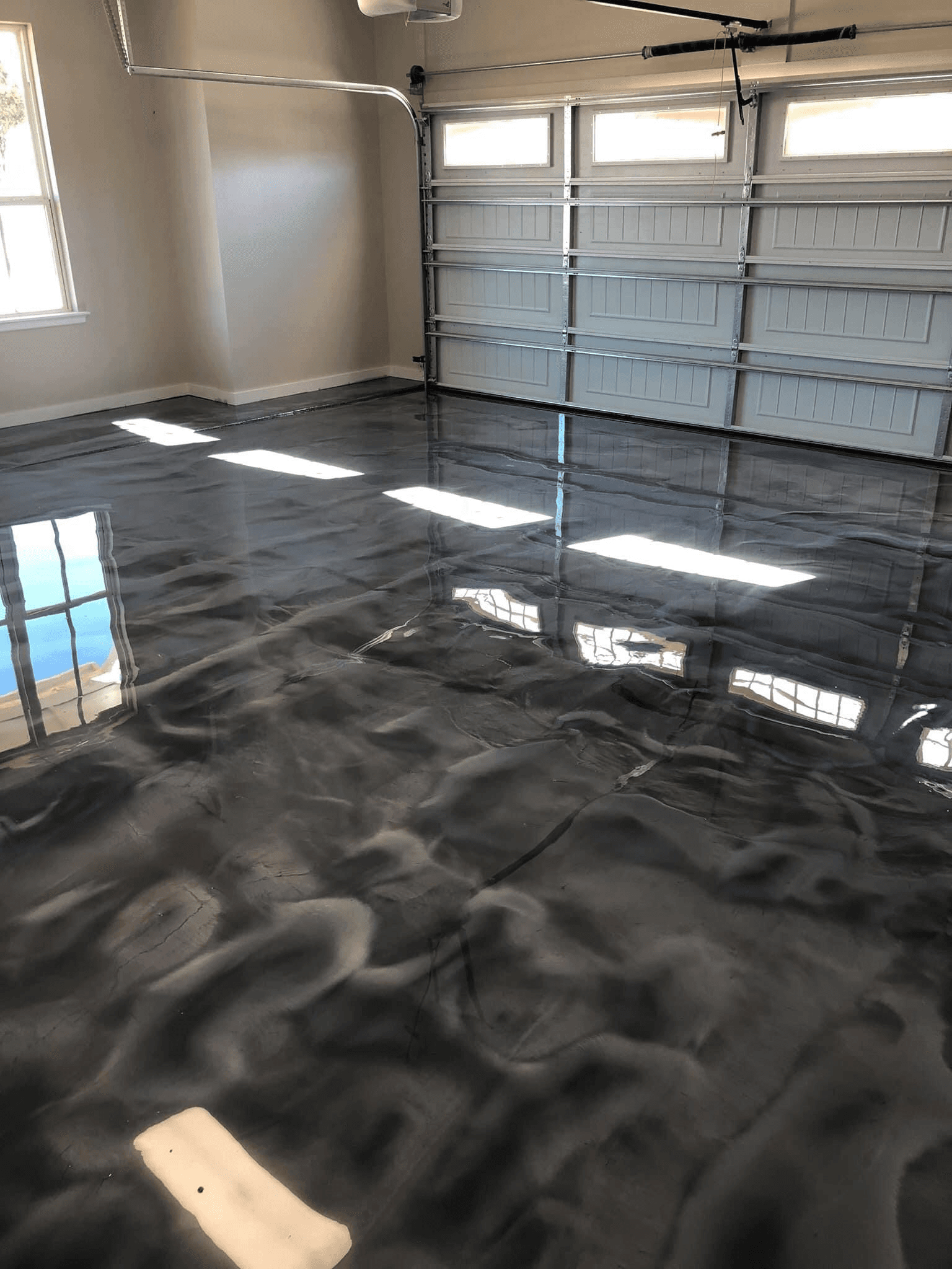 High-gloss metallic silver polymer floor coating finished in a two-car garage in Dorchester, Ontario