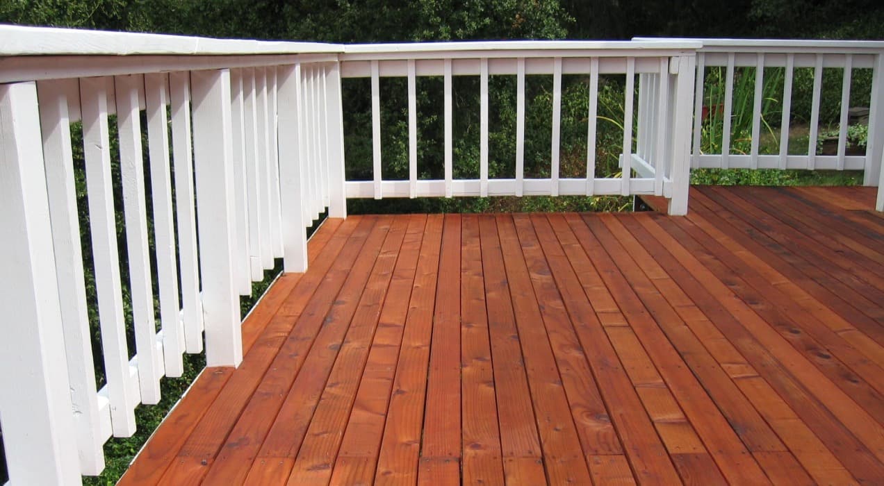 White railing and a freshly stained wooden deck